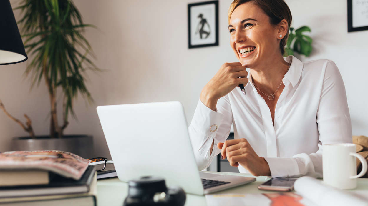 Practitioner on a computer using medspa management software and is smiling