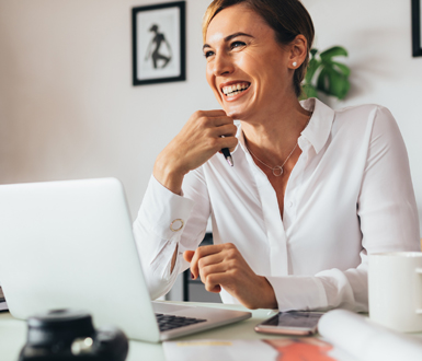 Practitioner on a computer using medspa management software and is smiling
