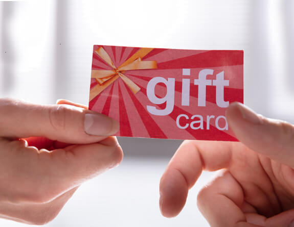 A medspa client holding a gift card.