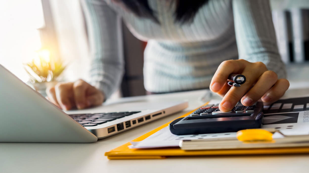 Person using a calculator and a laptop