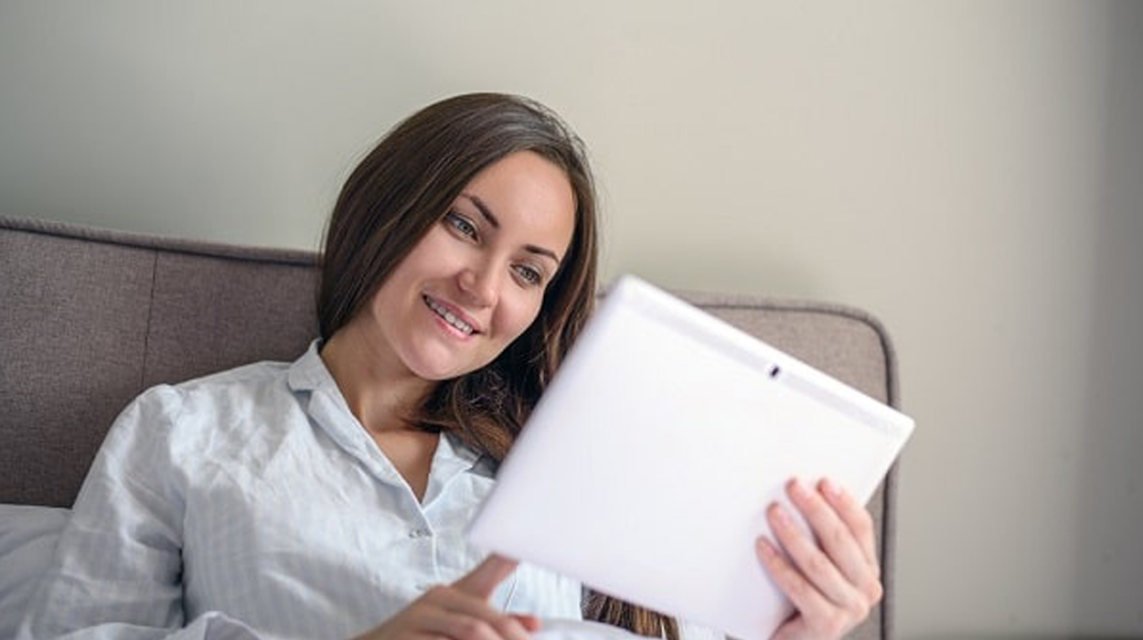 Person using a tablet in bed