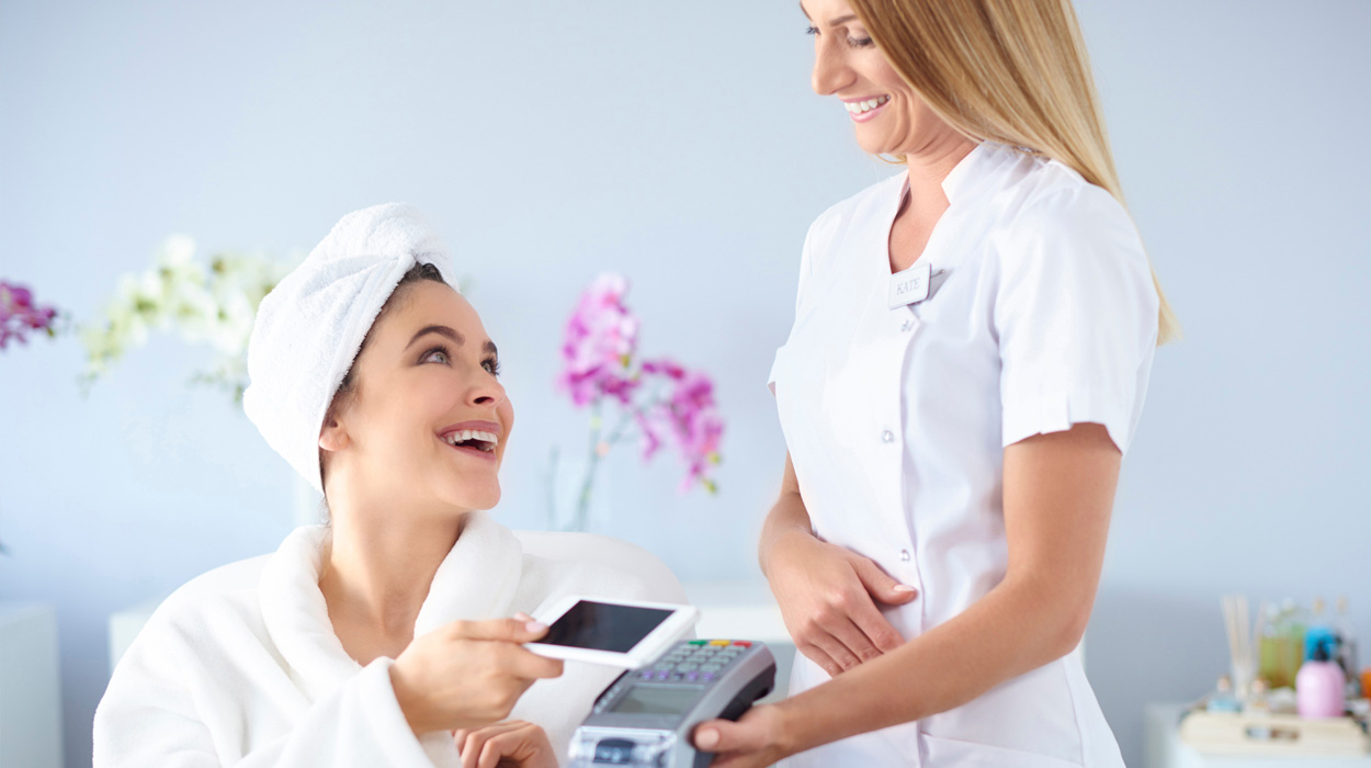 Client is paying using payment device connected to medical spa software.