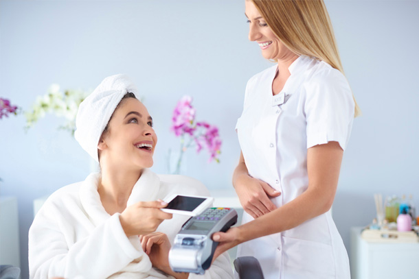 Client is paying using payment device connected to medical spa software.