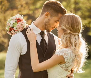 A couple at their wedding embracing and posing for a photo.