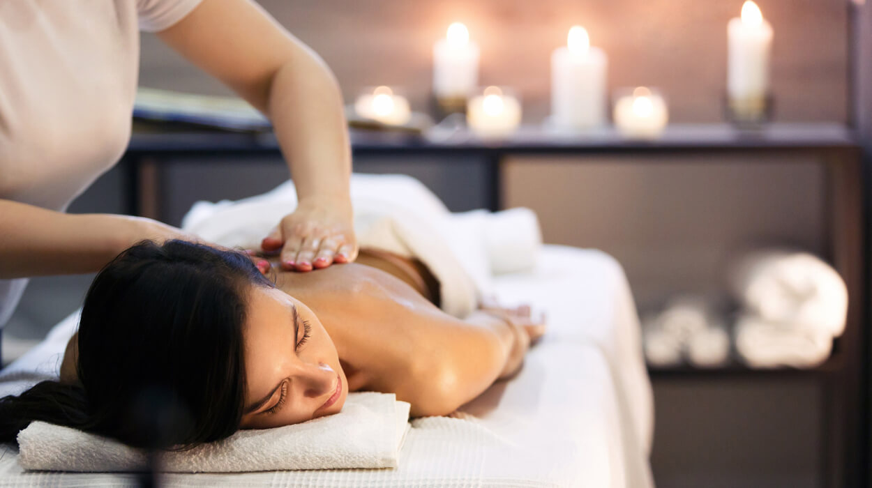 A person getting a massage in a candle lit room