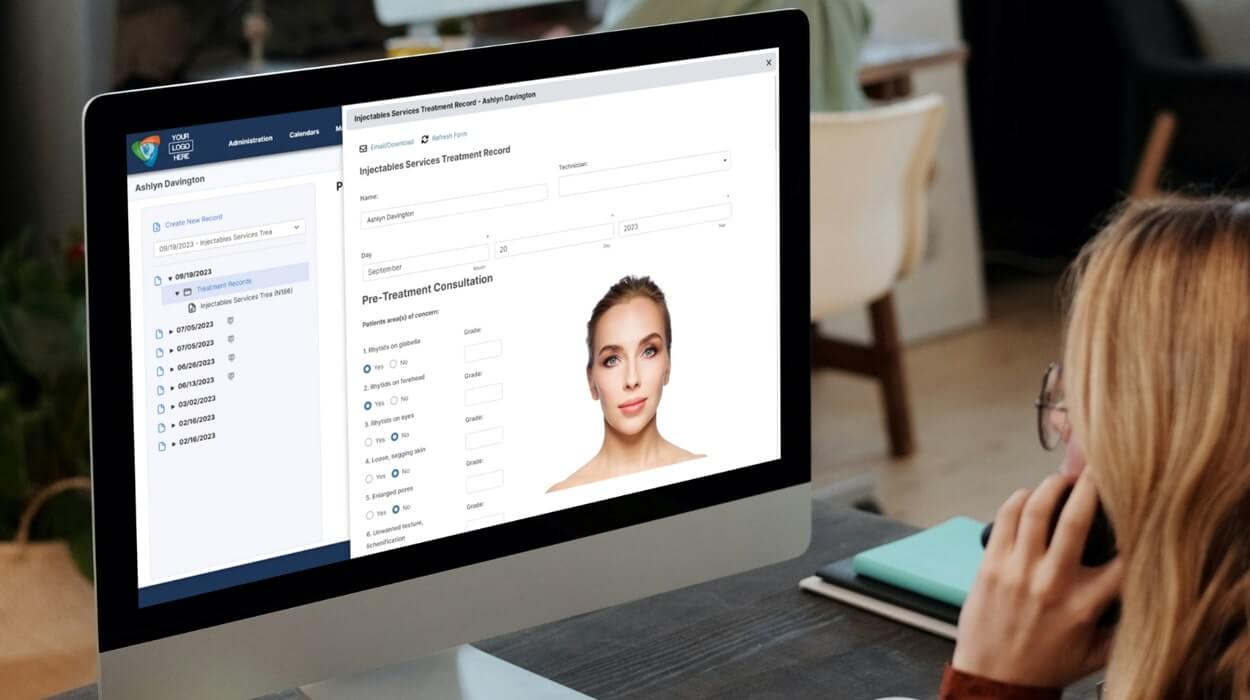 An aesthetics professional using medspa software while on the phone.