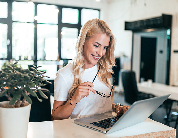 A happy medical spa business owner using the best EMR for medical spa as she works to streamline her operations in her business.