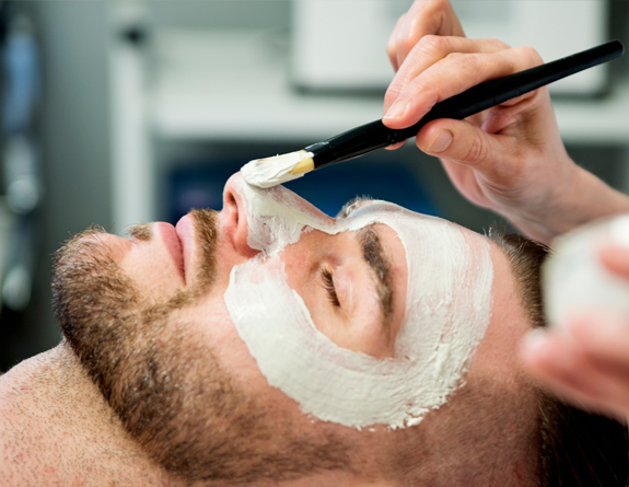 Father receiving a facial scheduled through aesthetics clinic software.