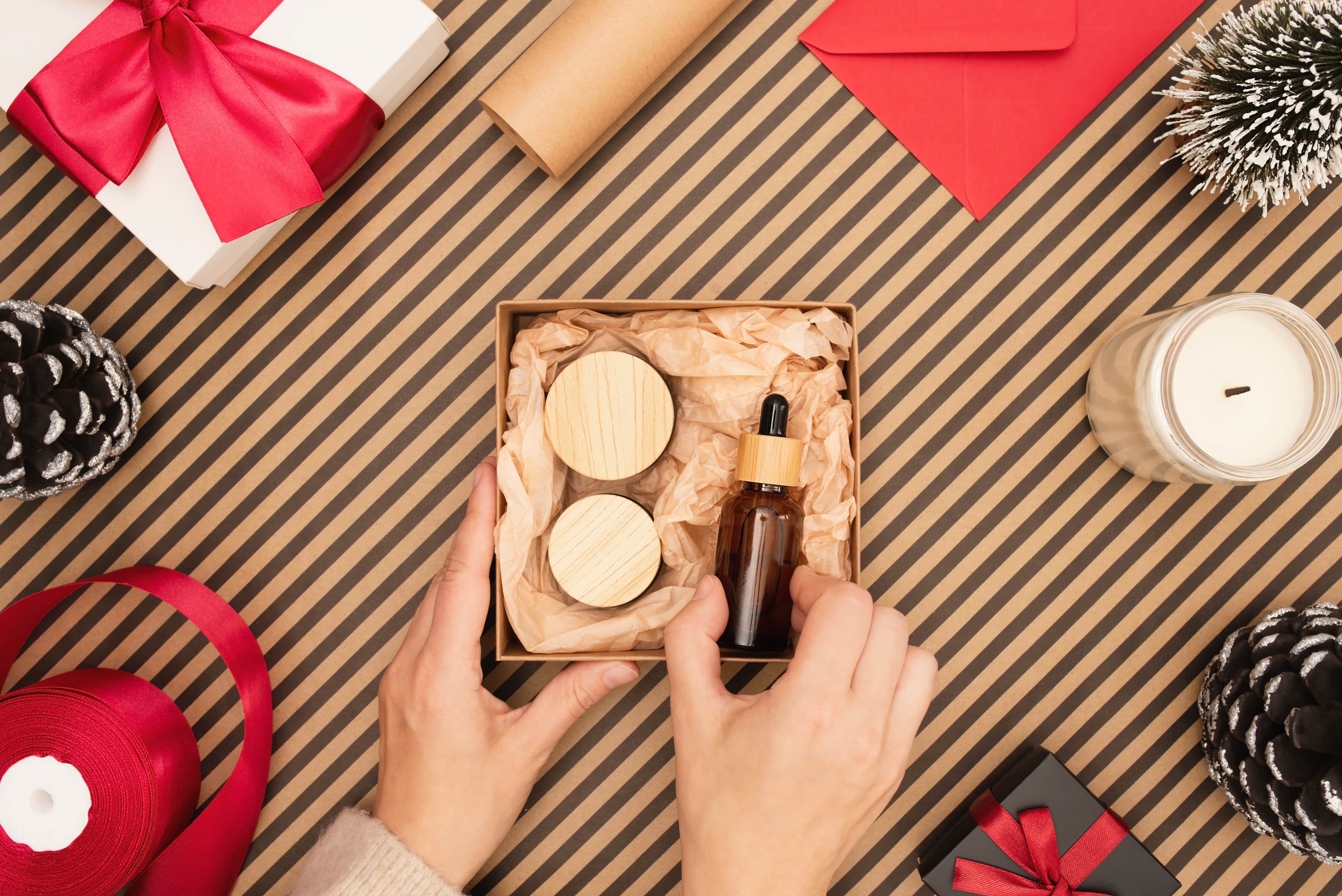 Individual puts spa products in gift box for the holidays