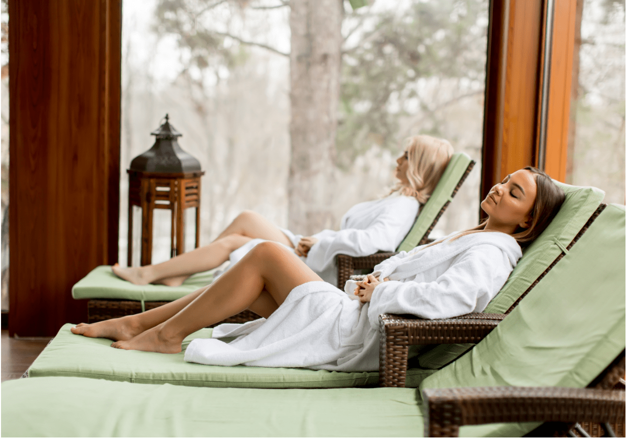 Two women relaxing on chairs in a spa environment.