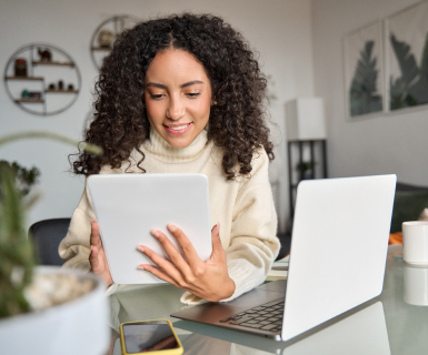 Aesthetician smiling and using spa software for small business on a tablet.