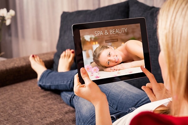 Person on a couch using a Tablet to browse spa software